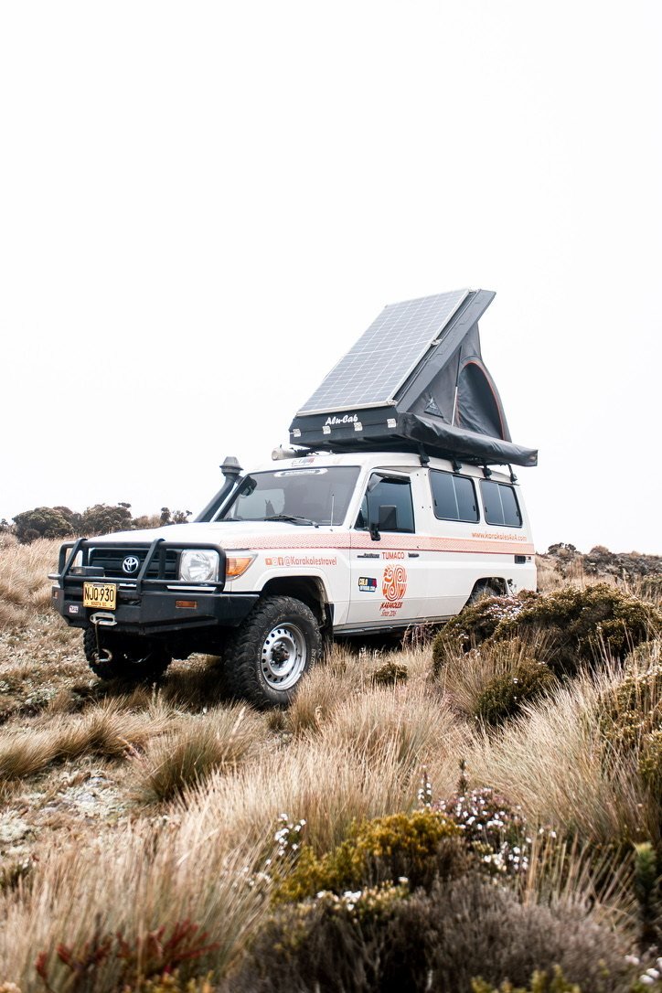 Land Cruiser de Karakoles acampado en el páramo, con la carpa de techo abierta y el panel solar