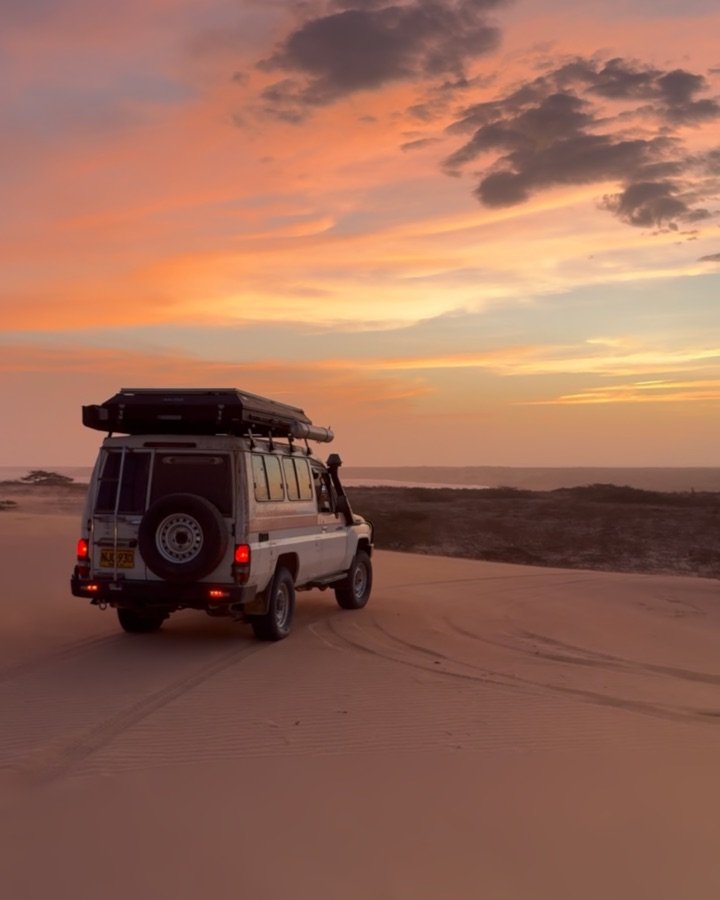 Land Cruiser mit Dachzelt am Strand bei Sonnenuntergang